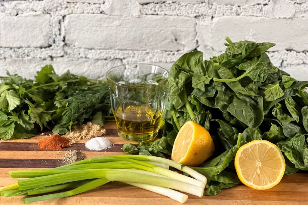 Photo of Sabzi ingredients, spinach, cilantro, dill, lemon, spices, olive oil