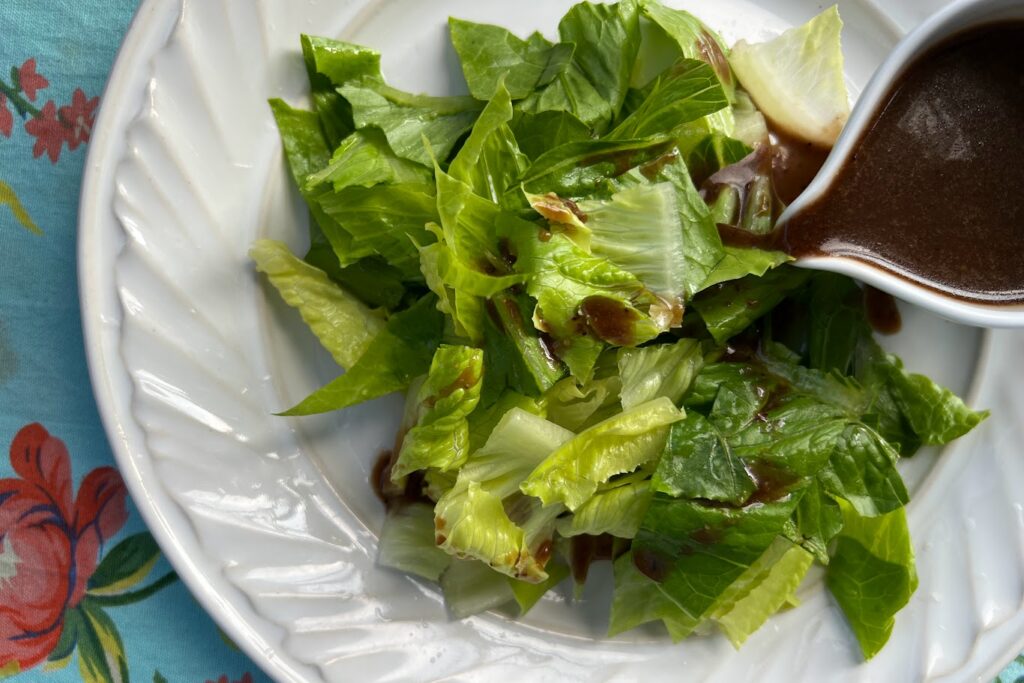 Chopped romaine on white plate drizzled with Honey Mustard Vinaigrette