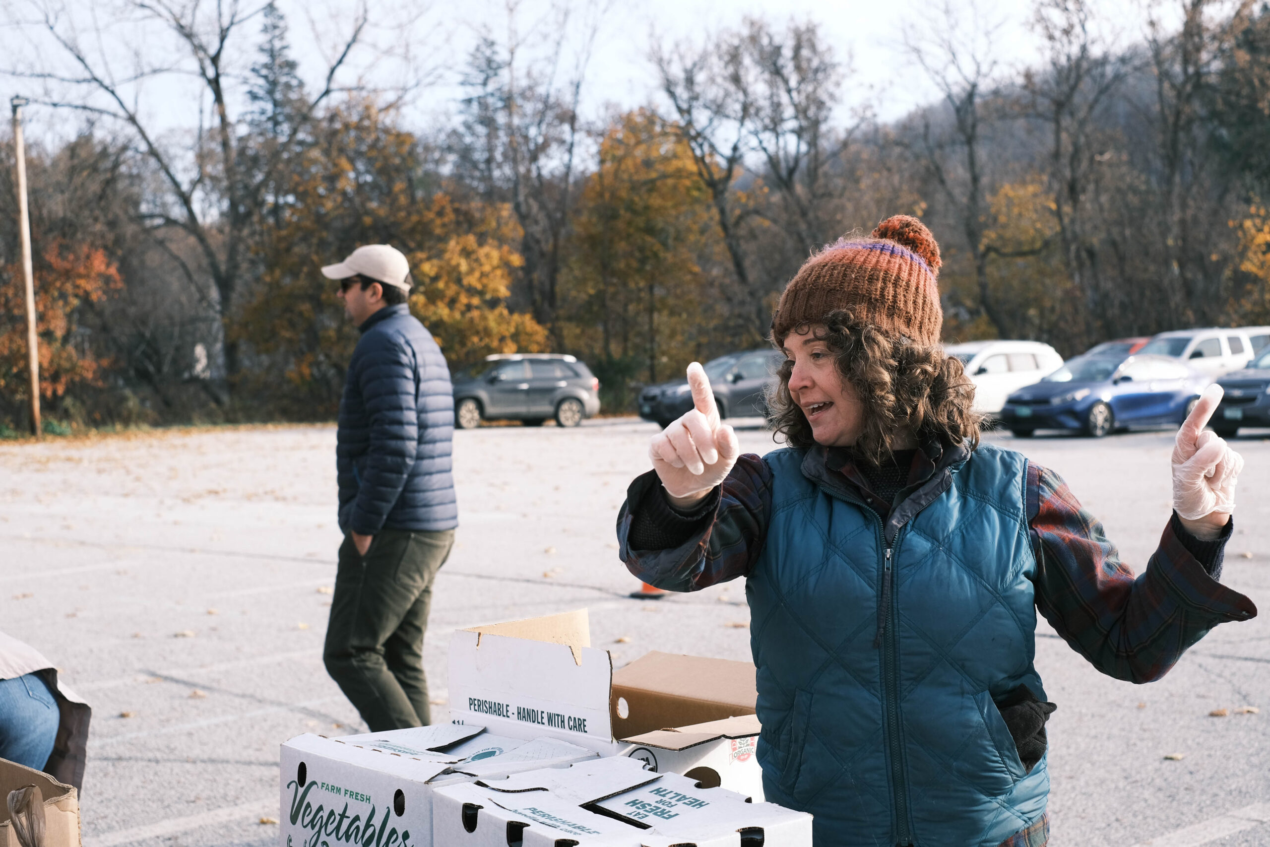 A Vermont Foodbank staff member directs traffic at a produce distribution event in Barre, Vermont.