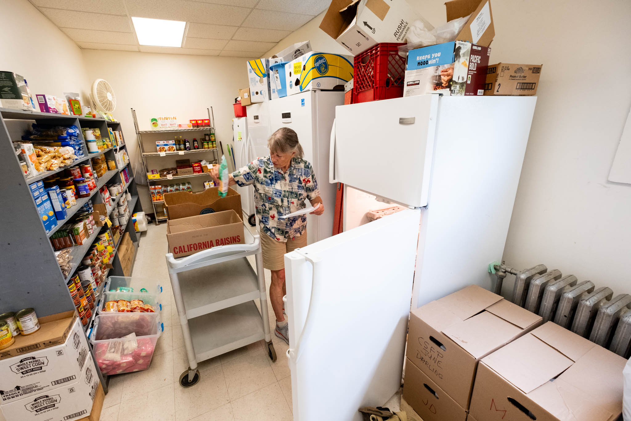Photo of a volunteer choosing food items at the Onion River Food Shelf.