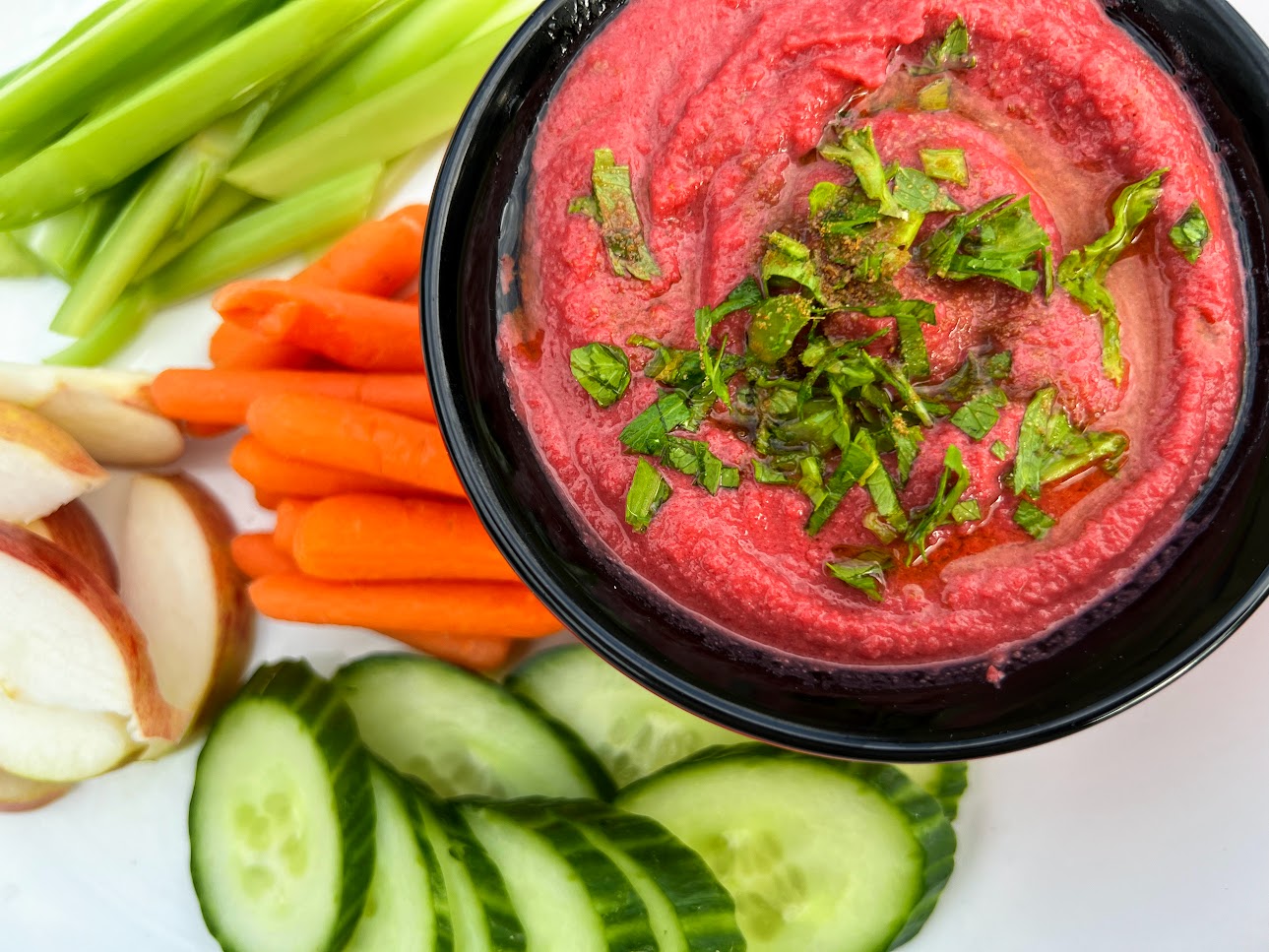 bowl of beet hummus with slices vegetables