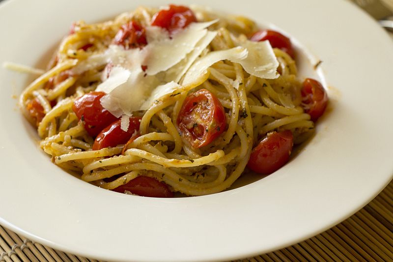 Bowl with spaghetti and cherry tomatoes topped with parmesan cheese