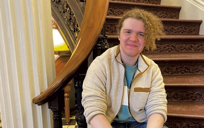 Photo of Matthew sitting on the inside steps of the Vermont State House. Matthew is one of many who are actively advocating for a food-secure Vermont.